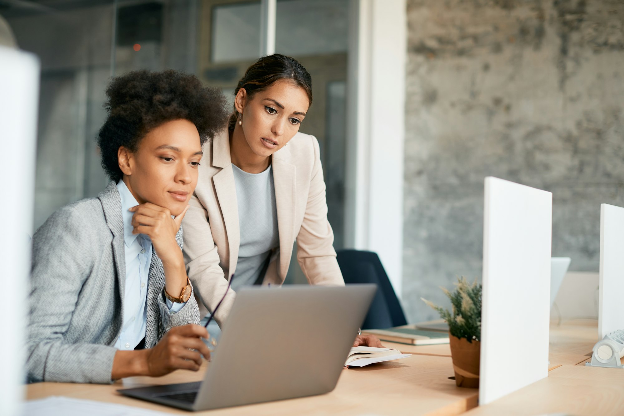 Businesswomen cooperating while working on laptop in the office.