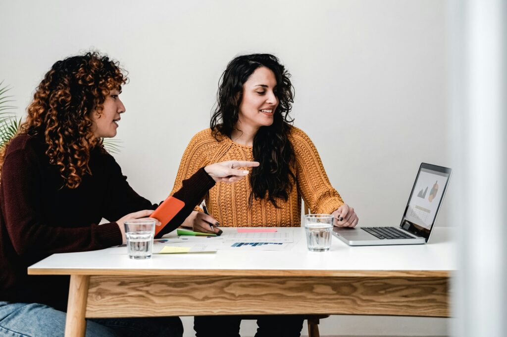 Latin young business women working inside modern office - Focus on right girl face