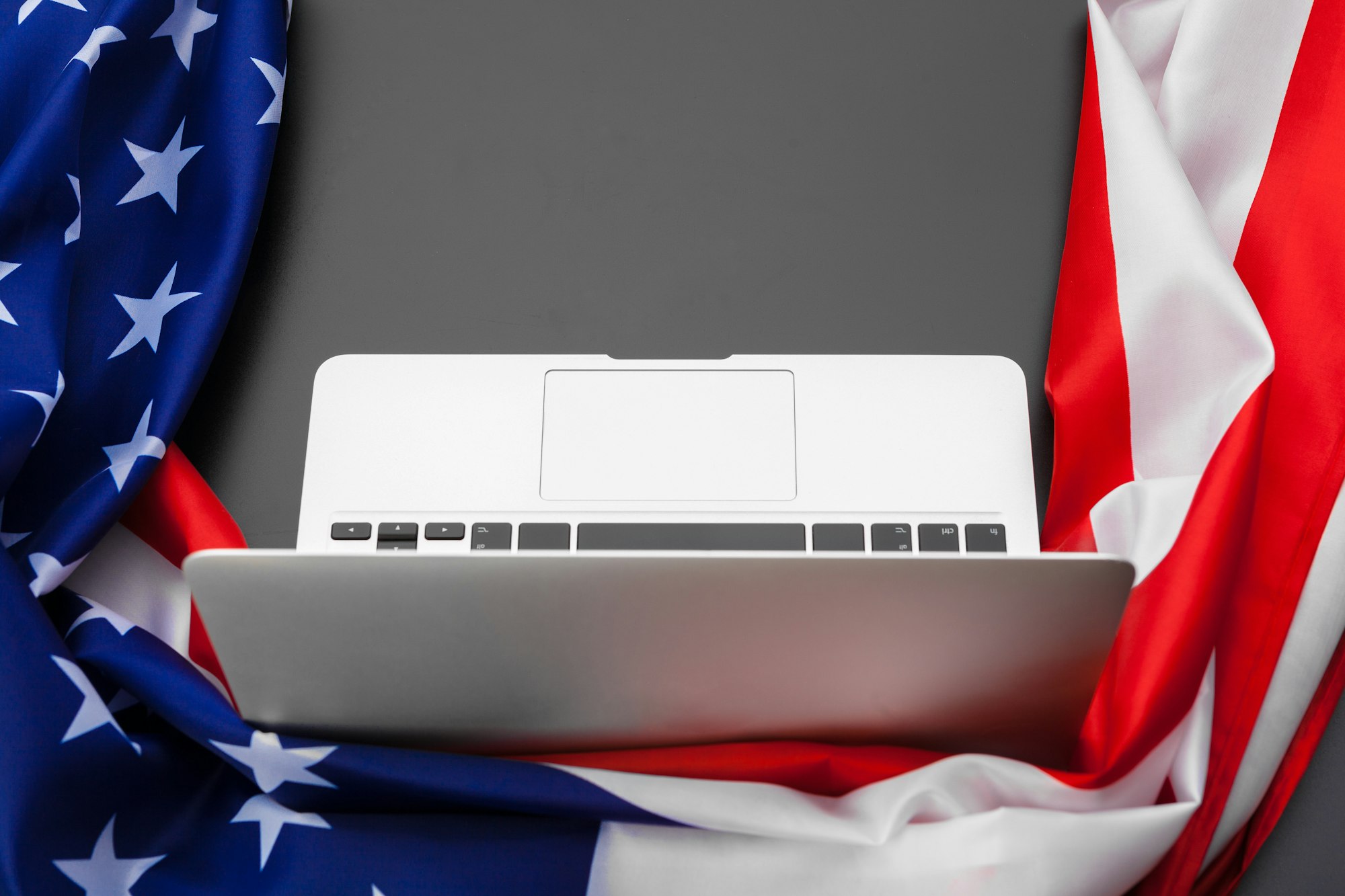 US flag and laptop on office desk top view