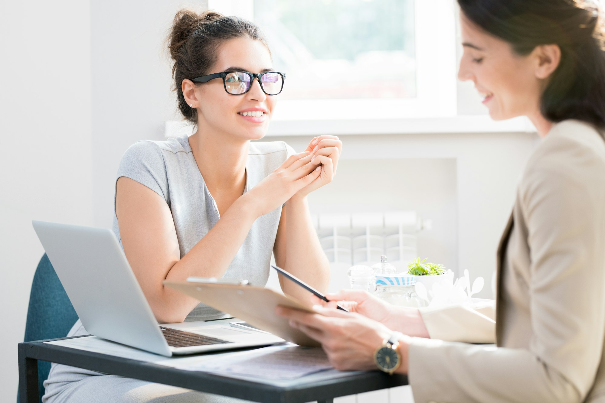 Young Businesswoman Talking to Partner in Cafe