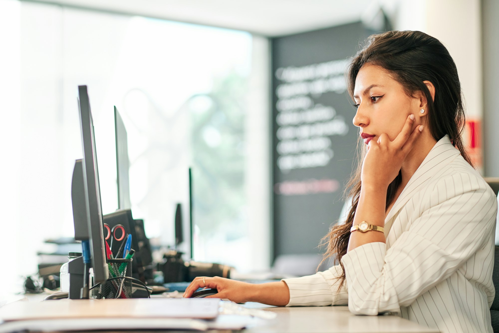 young latin businesswoman working at her office